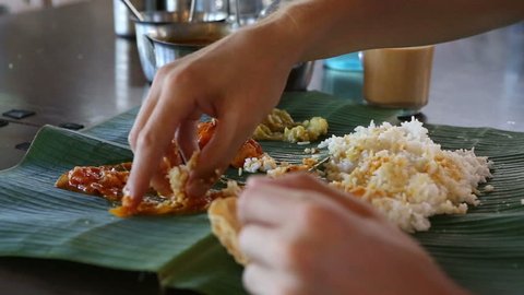 white man eats with his hands indian food from banana leaf like indian people