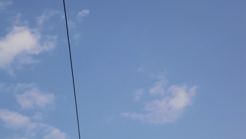 Camera tilt from blue sky to electricity pillars