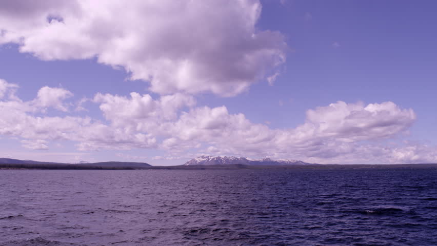 Flying clouds above lake and above snowy hilltop in Yellowstone National park, shot by 4K RED Epic camera,