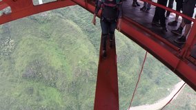 Base jumper jumping from a bridge with spectacular views of surrounding landscape.  Sky diving and parachuting daredevils B.A.S.E jump from great heights.