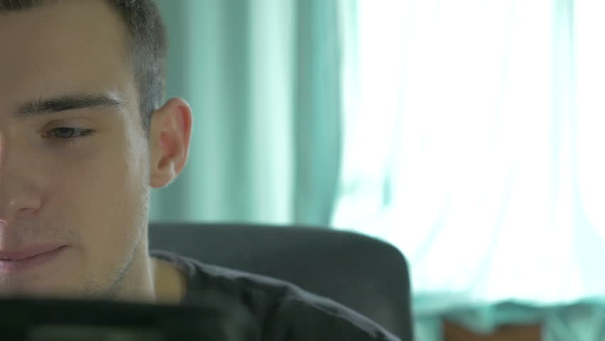 4k UHD - Young man browsing on a tablet pc and talking on the phone