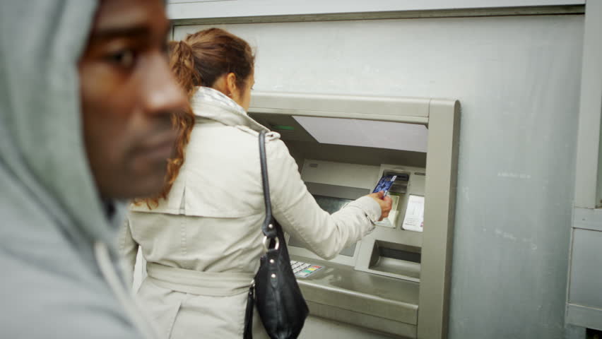 4K Suspicious character waits behind a woman as she takes money from an ATM machine | Shutterstock HD Video #8879251