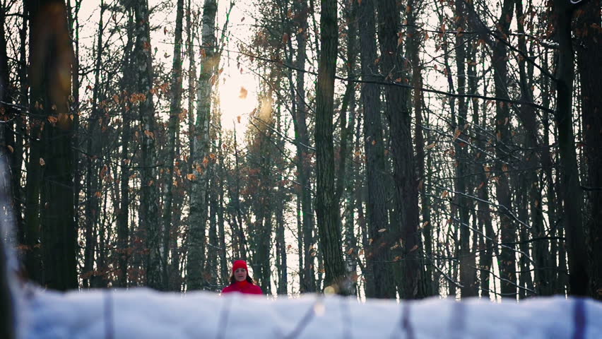 Jogger running in the snowy forest, steadycam shot, slow motion shot at 240fps
