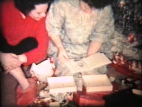 A family enjoys opening up Christmas presents together including the mother getting some new China. Stock Video