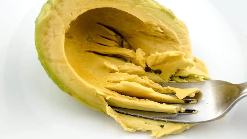 Mashing avocado into paste in slow motion with fork