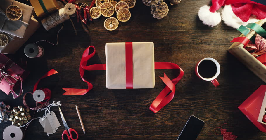 Top view woman wrapping christmas presents at wooden desk hands from above - Red Epic Dragon