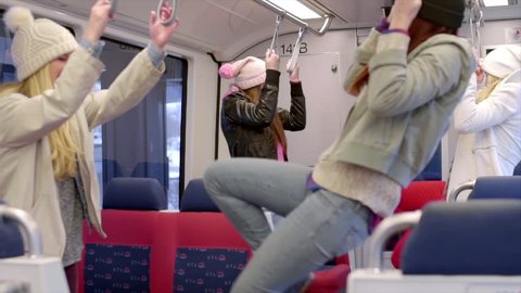 Teens Swing From Hand Holds On A Train, During A Stop, They Play A Game Of Trying To Get Each Other (Slow Motion)