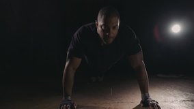 4k Stock Video clip of a boxer / weightlifter training by himself in a dark gym. Picture of determination and discipline.