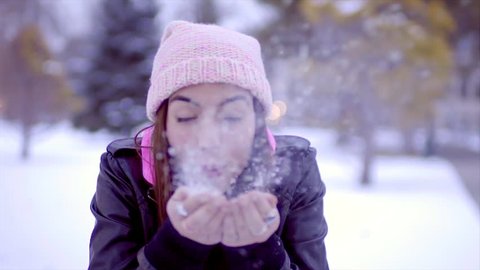 Hispanic Teen Girl Blows Handful Of Snow At Camera, Then She Throws The Rest In The Air And Smiles (Slow Motion)