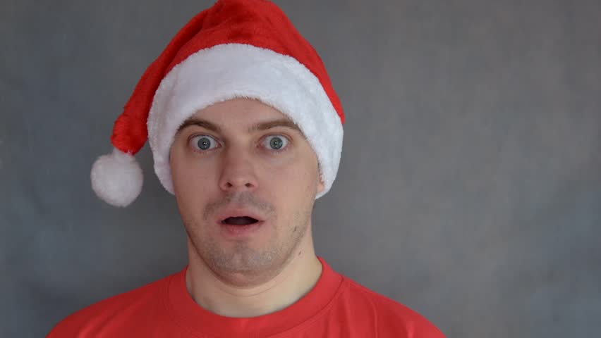 Young man in red santa hat  - surprised face.