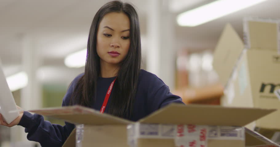 4K Team of workers in an electronics factory warehouse packaging goods and preparing deliveries