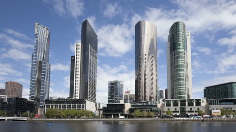MELBOURNE, AUSTRALIA - JAN 15, 2015: 4K Time lapse zoom out of waterfront skyscrapers at the Yarra River daytime with clouds