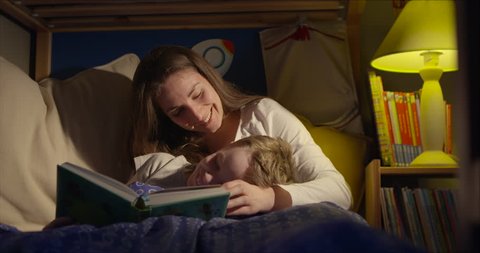 7 year old boy and his mum having a loving moment when reading a bedtime story
