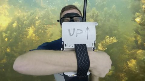Diving sign- divemaster  writes on the plate and shows ok sign GO UP, ASCENT 2  of 4 also a available on the green screen all of diving signs from course