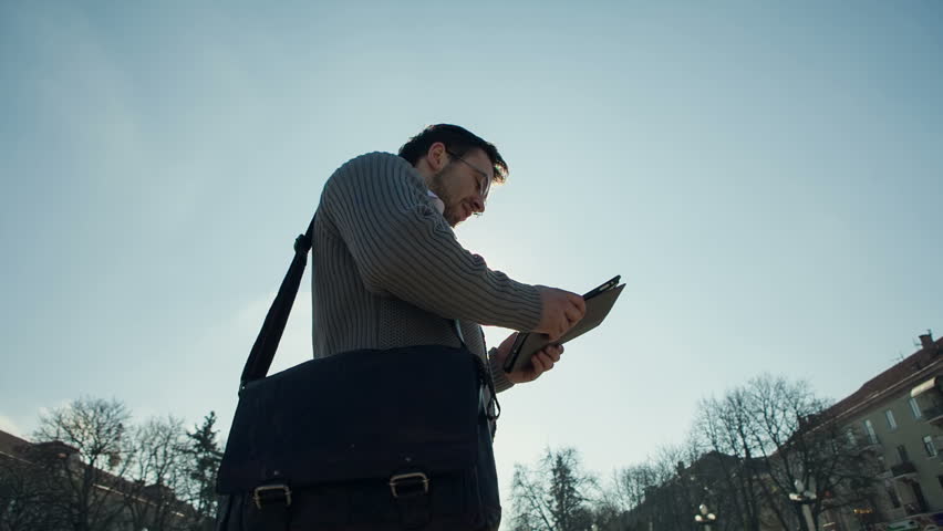Young handsome elegant model man using tablet technological device in the city