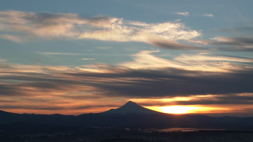 Time lapse from the Portland Oregon skyline with sun rising behind snowy Mt Hood on beautiful morning.