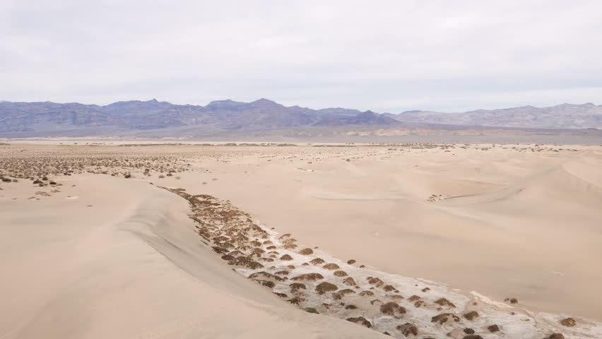 Panning Panorama of sand dunes in the desert landscape.The Mesquite Flat Sand Dunes are at the northern end of the valley floor and are nearly surrounded by mountains on all sides. 