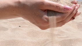 A close up of fine warm beach sand pouring through fingers. Suitable for tourism, travelling video illustration when need to express the quality, the pleasure and relaxation of warm beaches.