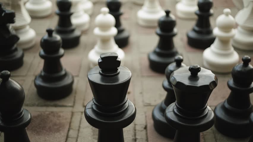Close-up shot of black and white Chess Pieces on a street
