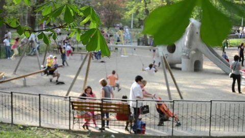 Kids and parents at playground enjoying a sunny afternoon in open air. Original ambience sounds included.