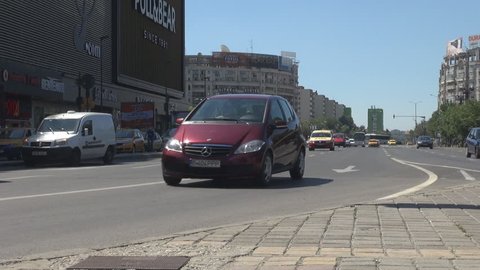 BUCHAREST, ROMANIA - FEBRUARY 20, 2015 Low angle view of car traffic, summer sunny day outside, driving cars downtown