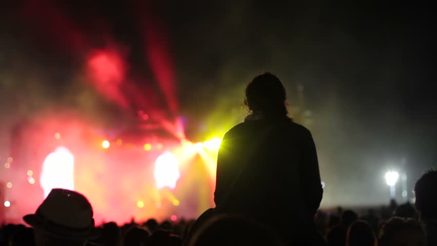 Girl having fun in the crowd at a concert with lights