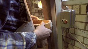 Clog maker is sanding a wooden clog with a sanding belt. Filmed in slow motion at 200fps