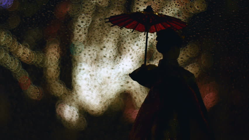 Variation of focus on doll wearing kimono watching flashing illumination in the rain.