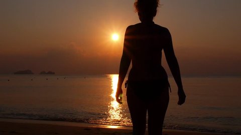 Silhouette of Woman Walking on Beach at Sunset. Slow Motion. HD, 1920x1080. Video Stok