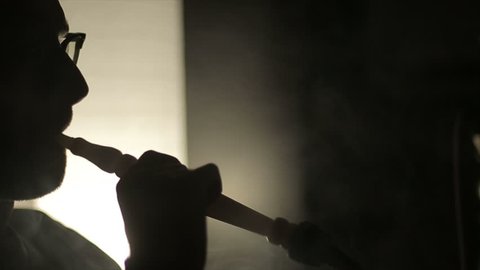 Shadow of a man smoking a hookah