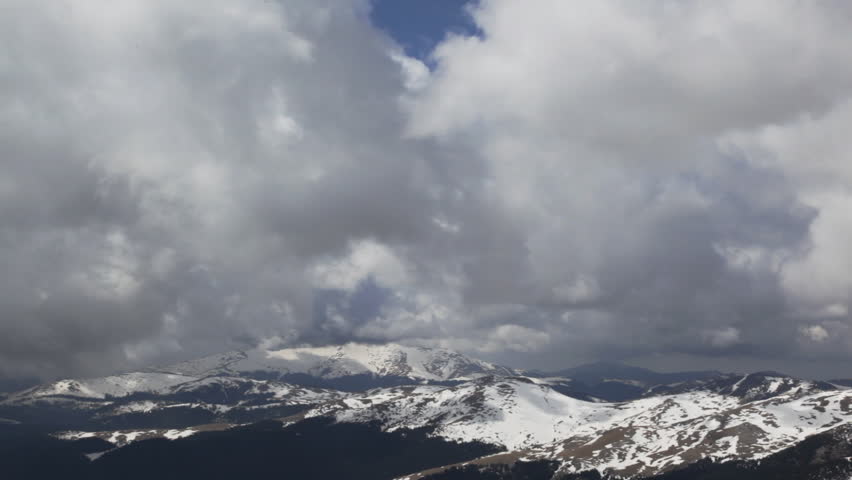 Snowy peaks and stormy clouds, camera panning