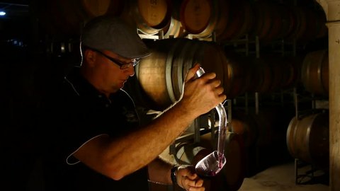 Footage of wine maker testing and tasting red wine in winery cellar featuring rows of oak barrels after vintage and harvest. Include Barossa Valley, Clare valley, Hunter Valley, Tanunda, Yarra,
