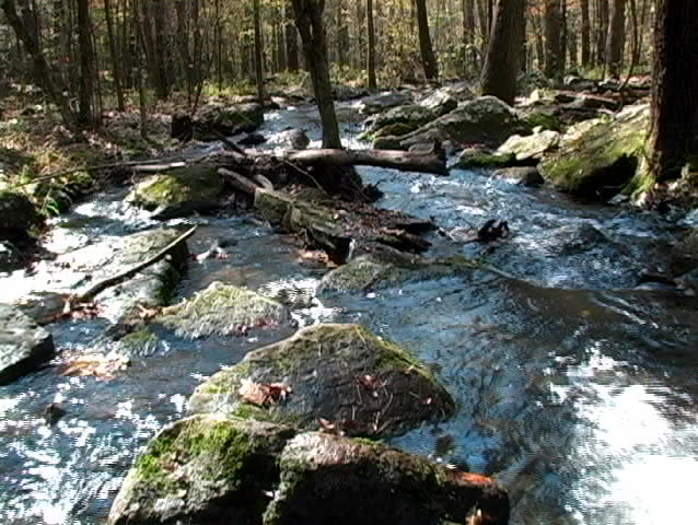 An overhead view of water flowing down a mountain stream over rocks.