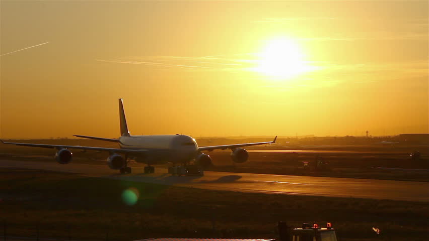 Airplane on airfield with sunset