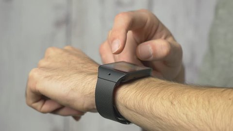 Arm of a man with a smart watch on his wrist being used.