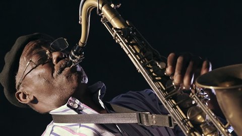 African man old black man playing saxophone dark background closeup Stock Video
