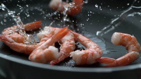 Shrimp splashing into hot oil in frying pan, slow motion; shot on Phantom Flex 4K at 1000 fps: stockvideo