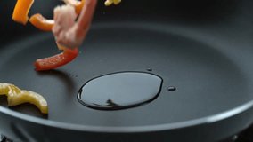 Stir fry splashing into hot oil in frying pan, slow motion; shot on Phantom Flex 4K at 1000 fps