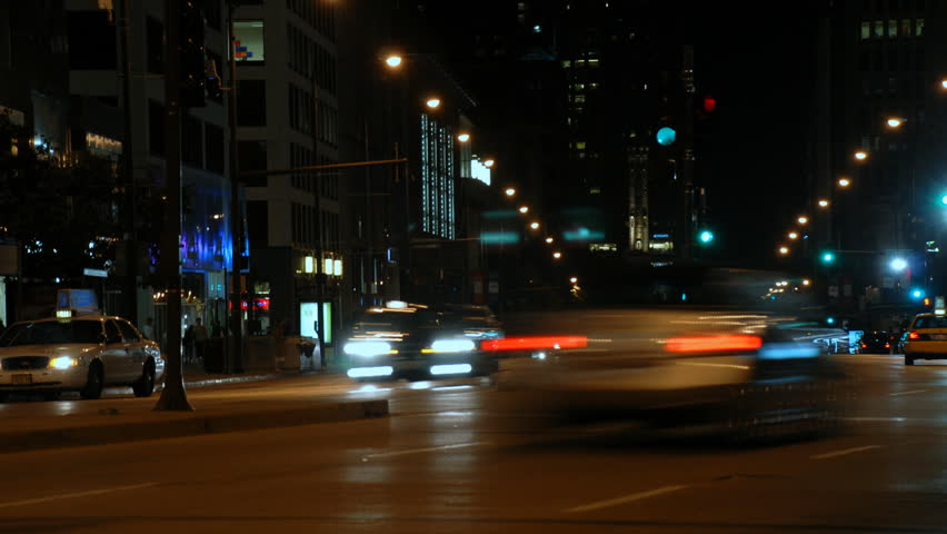 Traffic driving on a city street at night time lapse