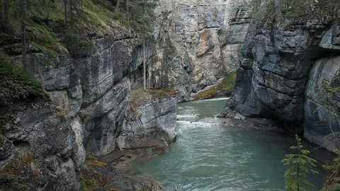 River gorge and flowing river at Maligne Canyon, Banff National Park, Alberta, Canada. Rushing water through narrow gorge created by the forces of water. Popular vacation and naturalist destination.
