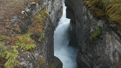 River gorge and waterfall Maligne Canyon, Banff National Park, Alberta, Canada. Rushing water pours through narrow gorge created by the forces of water. Popular vacation and naturalist destination.