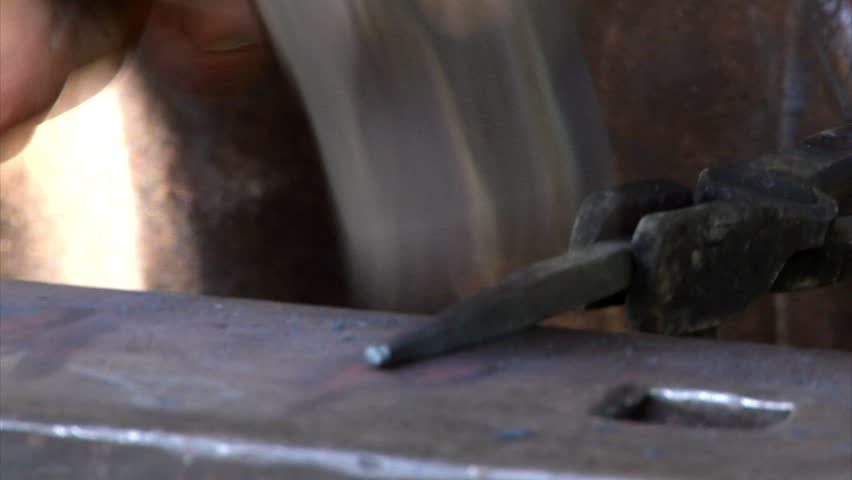 A blacksmith works on a project.
