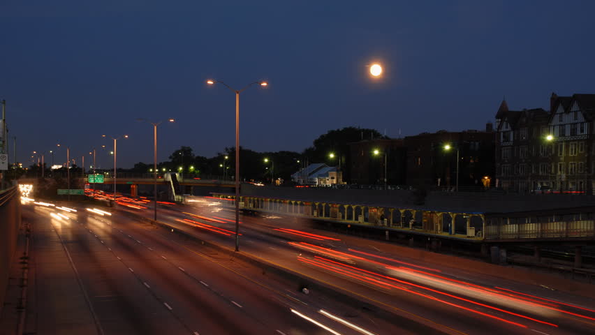 Moon rises over city rush hour motion blur time lapse