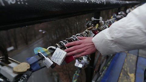 Bridge of Love with locks. Medium shot of woman's hand at locks