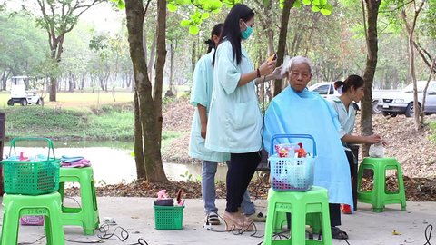 NAKHONSAWAN, THAILAND - FEBRUARY 21: unidentified people get haircut in outdoor barber in the park on February 21, 2015 in Nakhonsawan, Thailand.