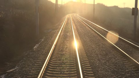 ULTRA HD 4K POV Point of view of train motion and sun ray, orange sunlight and parallel line track by day