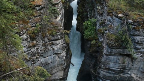 River canyon and gorge and river waterfall at Maligne Canyon, Banff National Park, Alberta, Canada. Rushing water pours through narrow gorge. Popular vacation and naturalist destination.