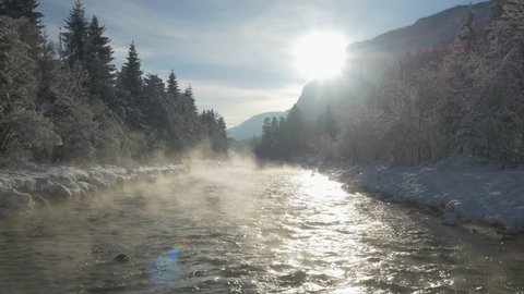 AERIAL: Mist above the snowy river in winter morning