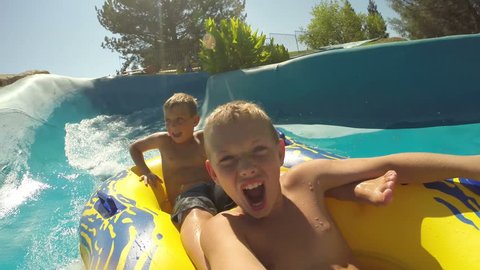 Kids going down a waterslide at waterpark, POV video