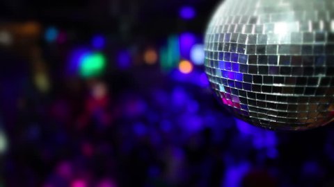 Nightclub dancing and flashing lights. Focus on foreground disco ball. Concept background with free text space.